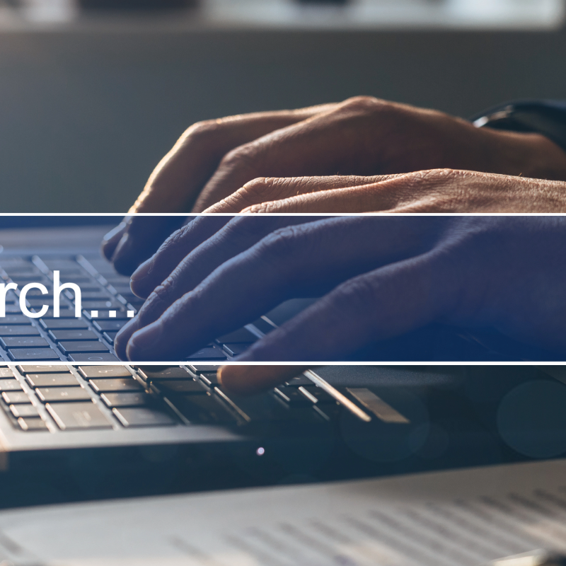 Hands typing on a laptop with a “Search…” text overlay.